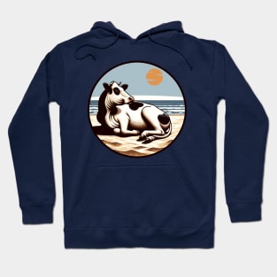 Cow lying on the beach Hoodie